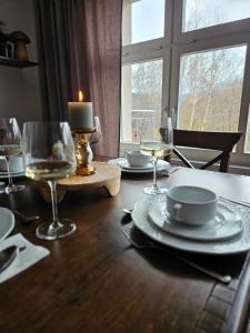 a table with plates and glasses and a candle on it at Dworek Szumilas in Prudnik