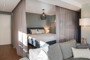 un soggiorno con un letto e un divano di Alpen Bijou mit Bergkulisse & Liebe zum Detail ad Adelboden