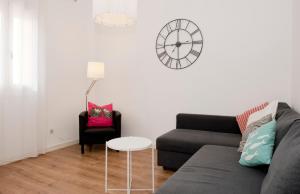 a living room with a couch and a clock on the wall at Apartamento Gaudí-Sant Pau in Barcelona