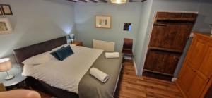 a bedroom with a bed with blue pillows on it at Beautiful Central Kendal Townhouse 3 Double Beds Free Parking in Kendal