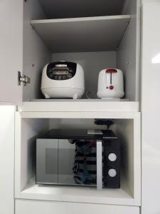 a shelf with a toaster and a toaster and a printer at Haeundae Bada Residence in Busan