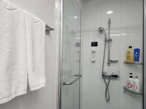 a bathroom with a shower with a glass door at Haeundae Bada Residence in Busan