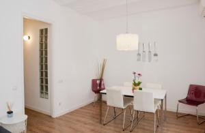 a dining room with white walls and a white table and chairs at Apartamento Gaudí-Sant Pau in Barcelona