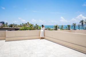 a woman standing on a balcony looking at the ocean at sea esta in Mount Lavinia