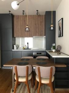 a kitchen with a wooden table and chairs in a kitchen at LoVE, modern apartment with pool & sea view in Tivat
