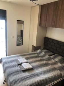 a bedroom with a bed with two towels on it at LoVE, modern apartment with pool & sea view in Tivat