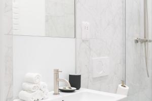 a white bathroom with a sink and a shower at Urban Chic – Drury in London