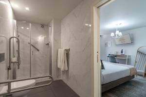 a bathroom with a shower and a bed in it at Templo Boutique Hotel in Évora +81 photos