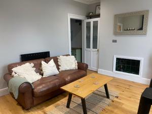 a living room with a brown couch and a coffee table at Charming and Stylish Redland One Bedroom Apartment in Bristol