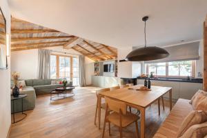 een keuken en een woonkamer met een tafel en stoelen bij Chalet Marmotta CULM - Luxus Chalet Ski-In Ski-Out in Sankt Anton am Arlberg