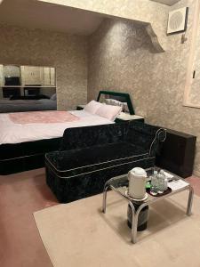 Yachimata的住宿－ロビンホテルRobin Hotel，一间卧室配有一张床、一张沙发和一张桌子