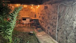 patio trasero con cocina, mesa y sillas en Peppina Home en Ghilarza