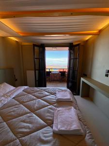 a bedroom with a large bed with a view of the ocean at Σκίουρος in Neráïda