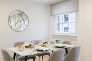 una sala da pranzo con tavolo, sedie e specchio di Urban Chic – Drury a Londra