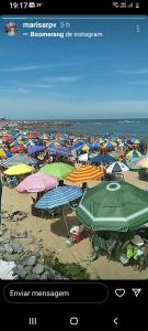 un grupo de coloridas sombrillas en una playa en Hospedaria Meu Lar, en Rio das Ostras