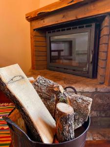 a basket of logs in front of a fireplace at Σκίουρος in Neráïda +46 photos