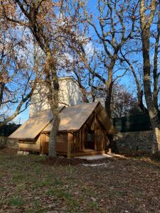 una cabaña de madera en el bosque con árboles en Villaggio Camping Bosco Selva, en Alberobello