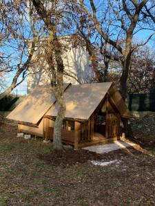 eine Blockhütte mit einem Zinndach neben einem Baum in der Unterkunft Villaggio Camping Bosco Selva in Alberobello
