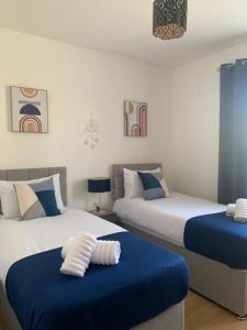 two beds in a room with blue and white at Sherwood- Nottingham Castle- Contractors- Free Parking- Long and Short Stays in Nottingham