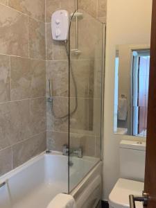 uma casa de banho com um chuveiro, uma banheira e um WC. em Sherwood- Nottingham Castle- Contractors- Free Parking- Long and Short Stays em Nottingham