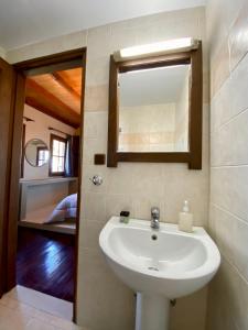 a bathroom with a sink and a mirror and a bed at Σκίουρος in Neráïda