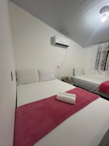two beds in a small room with a red blanket at Casa Recanto - Villa Uryah in Caraíva
