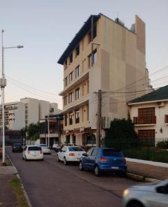 a street with cars parked in front of a building at Costanera Goya Apart & Hotel in Goya