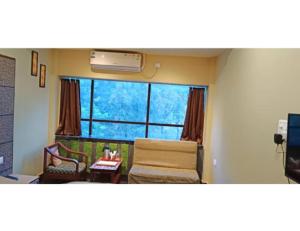 sala de estar con sofá y ventana en Hotel Hill Top, Bokaro, en Bokāro