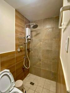 a bathroom with a shower with a toilet at The Pine Lush Hideout in Baguio
