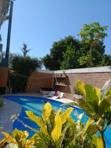 una piscina con una cama y una pared de ladrillo en Costanera Goya Apart & Hotel en Goya