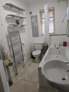 a white bathroom with a sink and a toilet at Twenty Four in Hythe