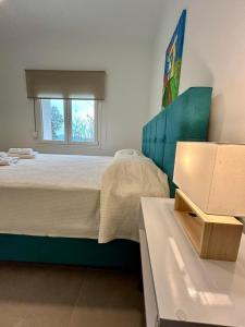 帕勒雍提費基翁的住宿－Adams Villa，一间卧室配有一张带蓝色床头板的床和一张桌子