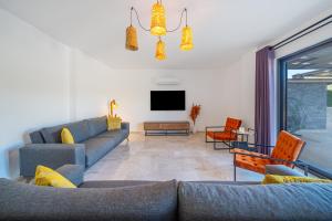 a living room with a couch and a tv at VILLA LIZYA in Kaş