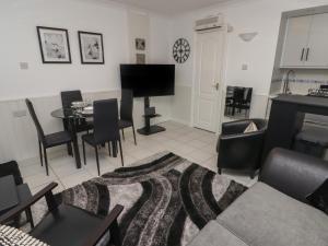 a living room with a table and a piano at Flat 7 in Tenby