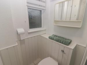 a white bathroom with a toilet and a window at Flat 7 in Tenby +8 photos