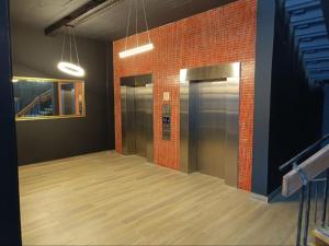 a hallway with two elevators and a brick wall at NEW BOSTON in Cape Town