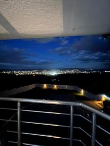 - un balcon offrant une vue sur la ville la nuit dans l'établissement TEA APARTMAN, à Niš