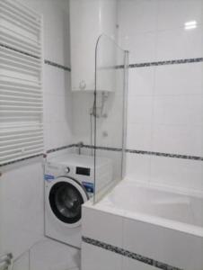 a washing machine in a bathroom with a window at TEA APARTMAN in Niš