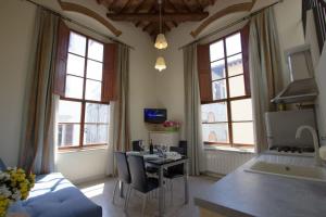 Il comprend un salon avec une table et une cuisine avec des fenêtres. dans l'établissement Santa Reparata Loft Florence, à Florence