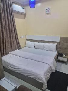 a bedroom with a large bed with white sheets at STAR DIAMOND VIEW LOUNGE & SUITE 