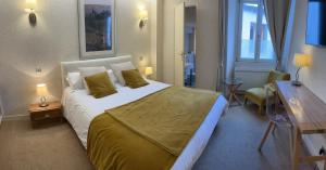 a bedroom with a large bed and a window at Logis Hôtel des Messageries in Arbois