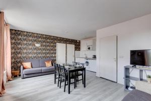 a living room with a table and chairs and a couch at 809 Suite Fantastic - Superb apartment in Bagnolet