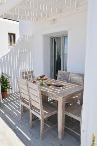 a wooden table and chairs sitting on a deck at Villa Areti Naxos in Glinado Naxos