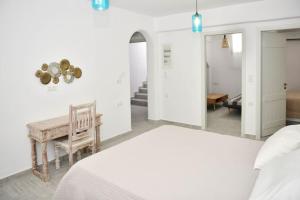 a white bedroom with a bed and a bench at Villa Areti Naxos in Glinado Naxos