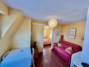 - un salon avec un canapé rouge et un lit dans l'établissement L'Horizon, à Villers-sur-Mer