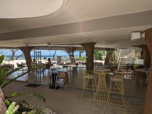 Maribago的住宿－Dominiks Stylish Resort Gem Ocean View Pool Queen Bed at Tambuli 8 Floor Fast Wifi，一间带桌椅的海景餐厅