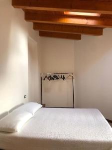 Cama blanca en habitación con techo en Mansarda Raffaello, en Seregno