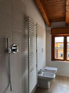 a bathroom with a sink and a toilet and a window at Mansarda Raffaello in Seregno