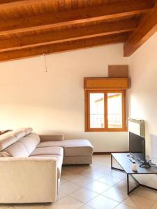 a living room with a couch and a television at Mansarda Raffaello in Seregno