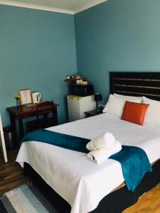 een slaapkamer met een groot bed met een blauwe muur bij Buxton lodge Guesthouse in Queenstown